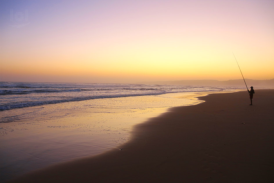 Brandungsangeln im Sonnenuntergang am Strand von George in Südafrika