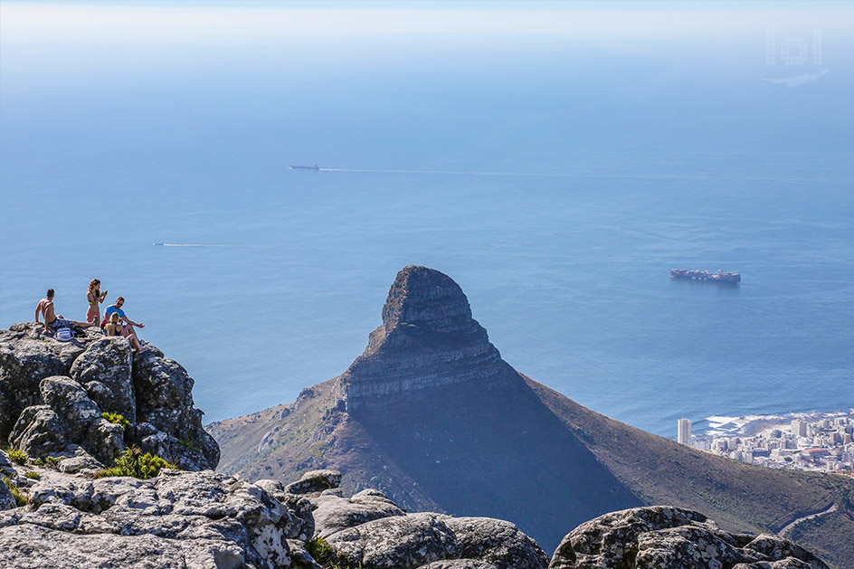 Ausblick vom Tafelberg auf den Löwenkopf, Kapstadt und eine Bergkuppe mit Touristen
