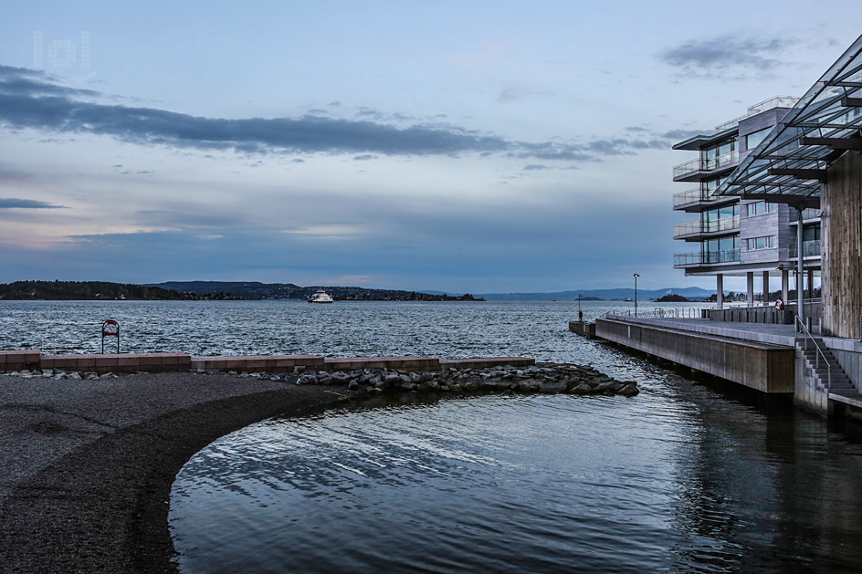 Ausblick auf das Wasser und die Inseln von Oslo Tjuvholmen mit Fähre in der blauen Stunde