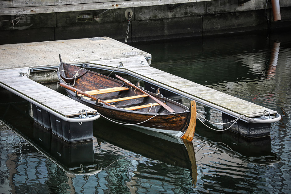 Traditionelles Holzboot mit Paddel in Oslo Tjuvholmen